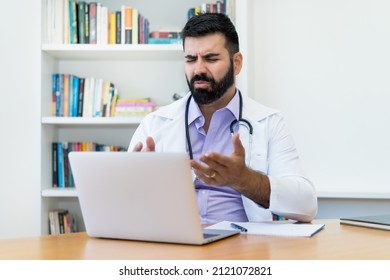 Latin American Mature Doctor At Video Call With Patient At Office Of Clinic