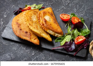 Latin American, Mexican, Chilean Food. Traditional Baked Pastry Empanadas With Beef Meat On A Dark Stone Background