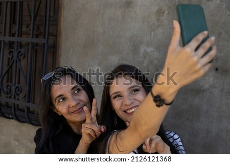 Similar – Männerhände fotografieren zwei glückliche Frauen im Freien.