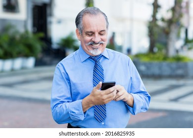 Latin American Senior Businessman Starting Video Call With Phone Outdoor In City In Summer