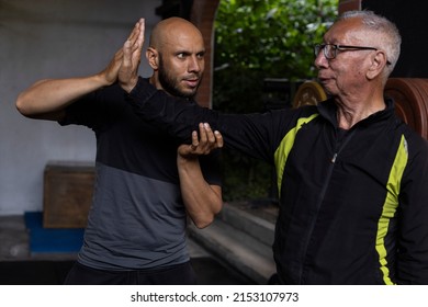 Latin American Senior Male And His Trainer Performing Rehabilitation And Therapy Exercises In The Gym. Healthy Lifestyle Concept.