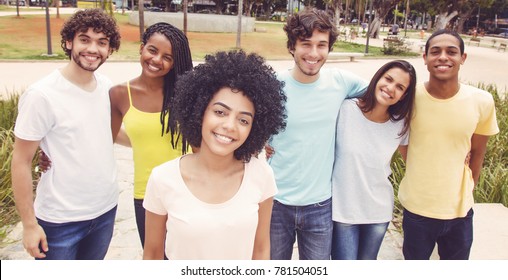 Latin American Woman With Group Of Friends In Retro Look Outdoors In The Summer