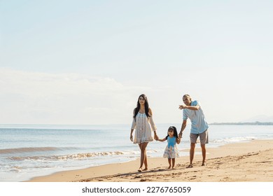 Latin american young family together walking on the beach. - Powered by Shutterstock