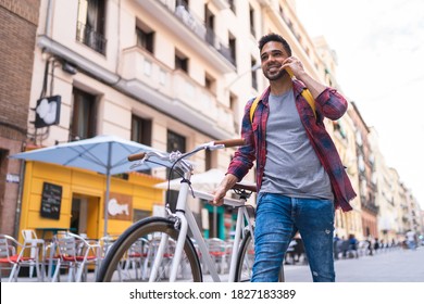 Latin American Young Man Using Phone Outdoors. Latino Man Having Phone Call In The Street. Lifestyle Concept.