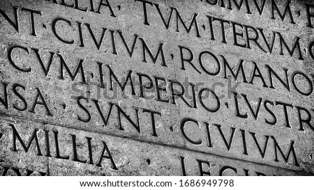 Latin ancient language and classical education. Inscription from Emperor Augustus famous Res Gestae (1st century AD), with the word Imperio in the center (Black and White)