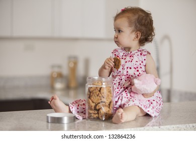 Latin Baby Girl Eating Cookies From A Jar