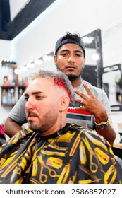 Latin barber posing while cutting hair to his client