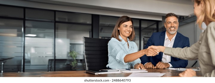 Latin business team of woman and European man shaking hands with colleagues, partners or employees, signing a contract. Group of people satisfied with results of team work together. Banner, copy space - Powered by Shutterstock