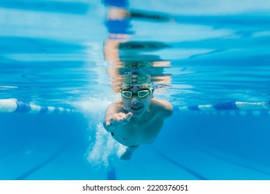 niños latinoamericanos nadadores con gorra y gafas en un entrenamiento submarino para nadar En la piscina de México América Latina
