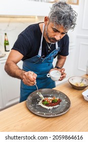 Latin Cook Cooking Octopus In The Kitchen. Chef Preparing Food For A Private Dinner At Home. Gourmet, Delicatessen Meal.