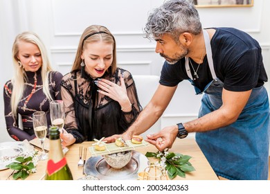 Latin Cook Serves Sushi Dish To An Attractive Client At Private Dinner Party. Excited Caucasian Woman Watching The Dish.