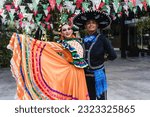 Latin couple of dancers wearing traditional Mexican dress from Guadalajara Jalisco Mexico Latin America, young hispanic woman and man in independence day or cinco de mayo parade or cultural Festival