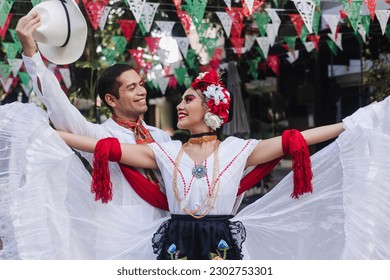 Latin couple of dancers wearing traditional Mexican dress from Veracruz Mexico Latin America, young hispanic woman and man in independence day or cinco de mayo parade or cultural Festival