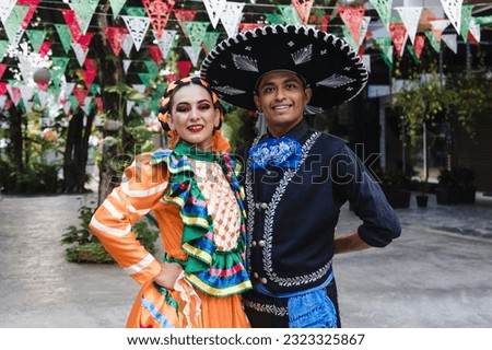 Latin couple of dancers wearing traditional Mexican dress from Guadalajara Jalisco Mexico Latin America, young hispanic woman and man in independence day or cinco de mayo parade or cultural Festival