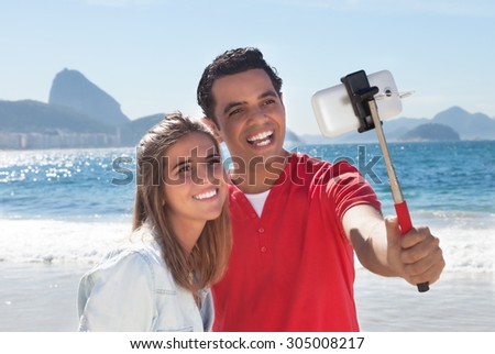 Latin couple at Rio de Janeiro taking a selfie with stick