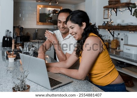 Latin couple using laptop or computer at home in Mexico Latin America, hispanic young people consulting the internet