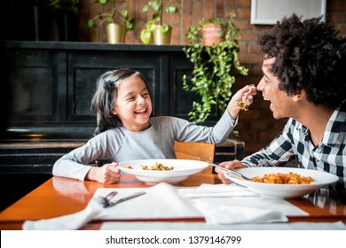 Latin dad and daughter eating together lunch at restaurant, multiethnic family having fun - Powered by Shutterstock