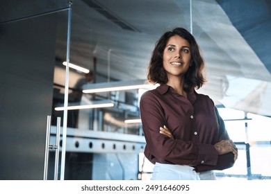 Latin or eastern middle age female ceo leader businesswoman standing in office. Portrait of beautiful successful hispanic young business woman with crossed arms looking confident aside. Copy space