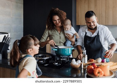 latin family cooking together with children daughter and son in kitchen at home in Mexico Latin America, hispanic people - Shutterstock ID 2297889501