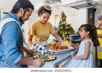 Latin family cooking together for Christmas dinner at home in Mexico Latin America, hispanic mother, grandparents and daughter preparing turkey meat in holidays - Powered by Shutterstock