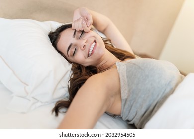 Latin girl waking up in a very comfortable bed
