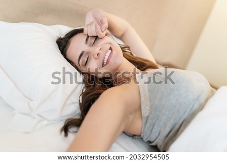 Latin girl waking up in a very comfortable bed