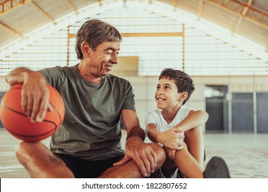 Latin grandfather and grandson playing basketball on the court - Shutterstock ID 1822807652