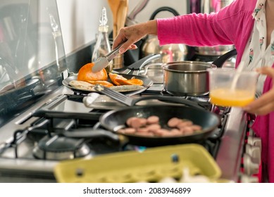 Latin Grandma Cooking Some Enchiladas And Frying Sausage