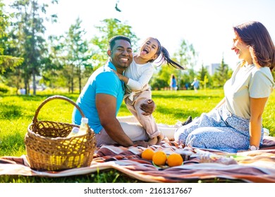 Latin Hispanic Dad And European Mom With Cute Child At Picnic In Sunny Day