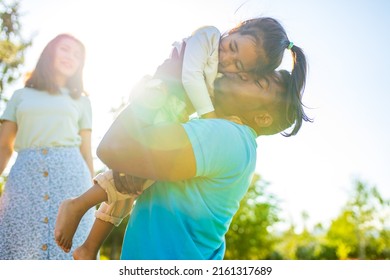 Latin Hispanic Dad And European Mom With Cute Child At Picnic In Sunny Day