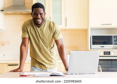 Latin Hispanic Man Looking Happy With Laptop And Papers At Kitchen