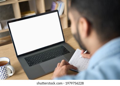 Latin Indian Adult Student Having Virtual Meeting Online Call Training Educational Webinar Chatting Working At Home Office Using Laptop Computer Looking At Mockup Empty Screen. Over Shoulder View.