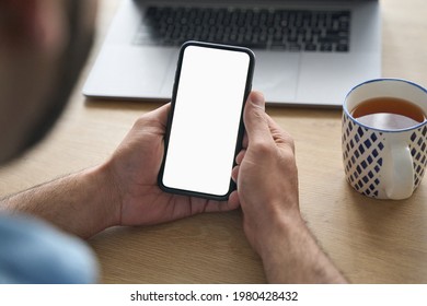 Latin Indian Adult Student Holding Using Mock Up Of Cell Mobile Smartphone With Empty Blank White Screen For Advertising. Over Shoulder Closeup View.