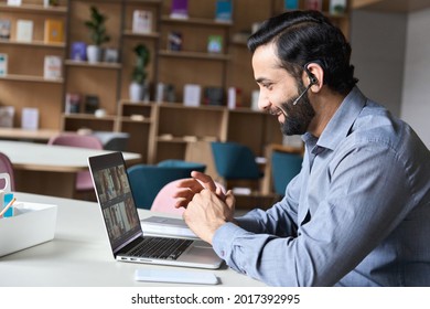 Latin indian smiling businessman wearing headset having virtual team meeting group call chatting with diverse people in customer support. Video conference call on computer with manager and employees. - Shutterstock ID 2017392995