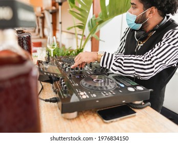 Latin Man DJ Mixing Music Outdoor At Beach Club While Wearing Safety Face Mask For Coronavirus Outbreak