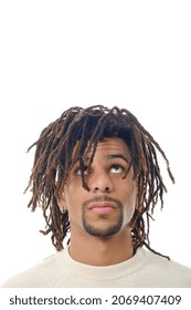 Latin man with dreadlocks looking up while standing against an isolated background.