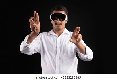 Latin man experiencing virtual reality in modern vision pro vr glasses, interacting with virtual screens gesturing hands and touching invisible touchscreen, black background