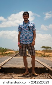 Latin Man With A Flowered Tshirt Poses On Empty Train Tracks 