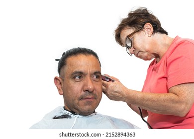 Latin Man With His Long Hair Pulled Back While An Older Woman Gives Him A Haircut