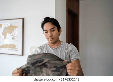 Latin Man Holding His Camo Jacket