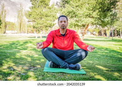 Latin Man Meditating In The Sunny Park 