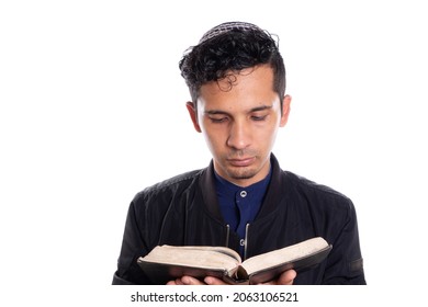 Latin man practicing Judaism isolated on white background. Young man with kippah reading bible.