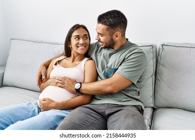 Latin man and woman couple hugging each other expecting baby at home - Powered by Shutterstock