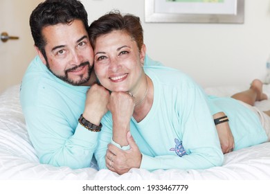 Latin Mature Couple Looking At Their Cellphone 