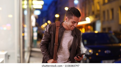 Latin Millennial Guy On City Street At Night Hailing A Cab Or Rideshare Car