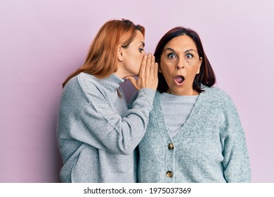 Latin mother and daughter wearing casual clothes hand on mouth telling secret rumor, whispering malicious talk conversation  - Powered by Shutterstock