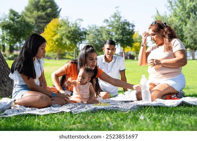 Latin multigenerational family celebrating Peru Day by having a picnic - Powered by Shutterstock