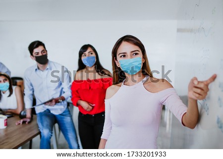 Latin People teamwork working in business office or coworking while wearing face mask for social distancing in new normal situation protecting and preventing the infection of corona virus or covid-19