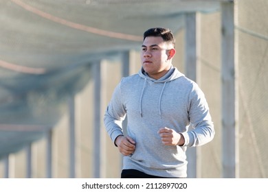 Latin runner jogging and wearing a hoodie - Powered by Shutterstock