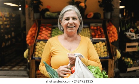 Latin senior woman shopping at farm market. Customer buying at grocery store. Small business concept. Black and white editing - Powered by Shutterstock